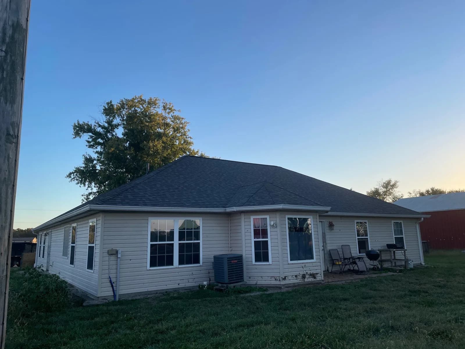 Completed home with white siding, a charcoal roof, and new gutters near Warren County